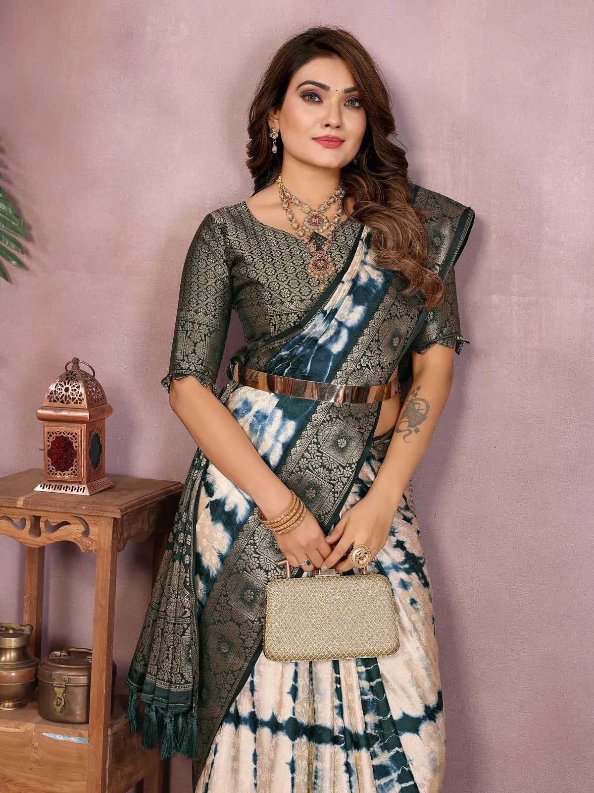 Woman wearing a traditional saree with a matching blouse against a pink background